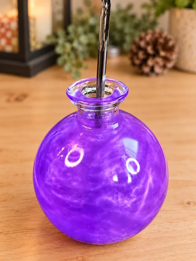 Mixing shimmering purple liquid in a glass potion bottle